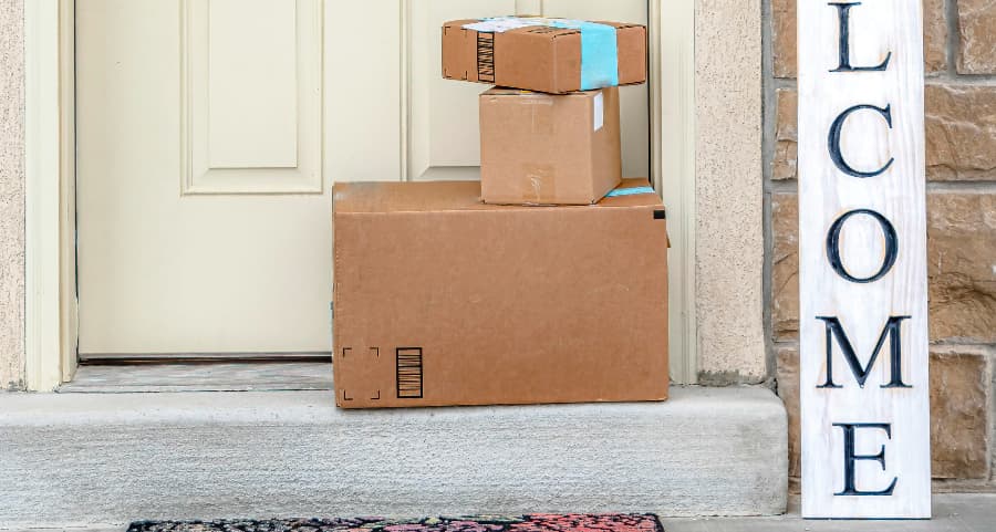 Boxes by the door of a residence with a welcome sign in Lawrence